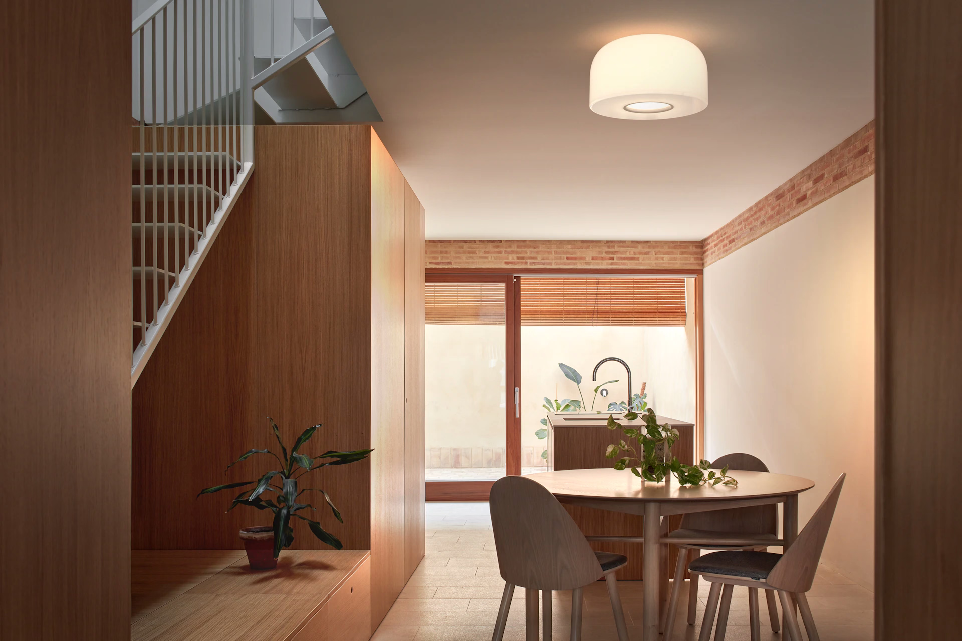 FLOS Bellhop Glass Suspension illuminating a modern dining space